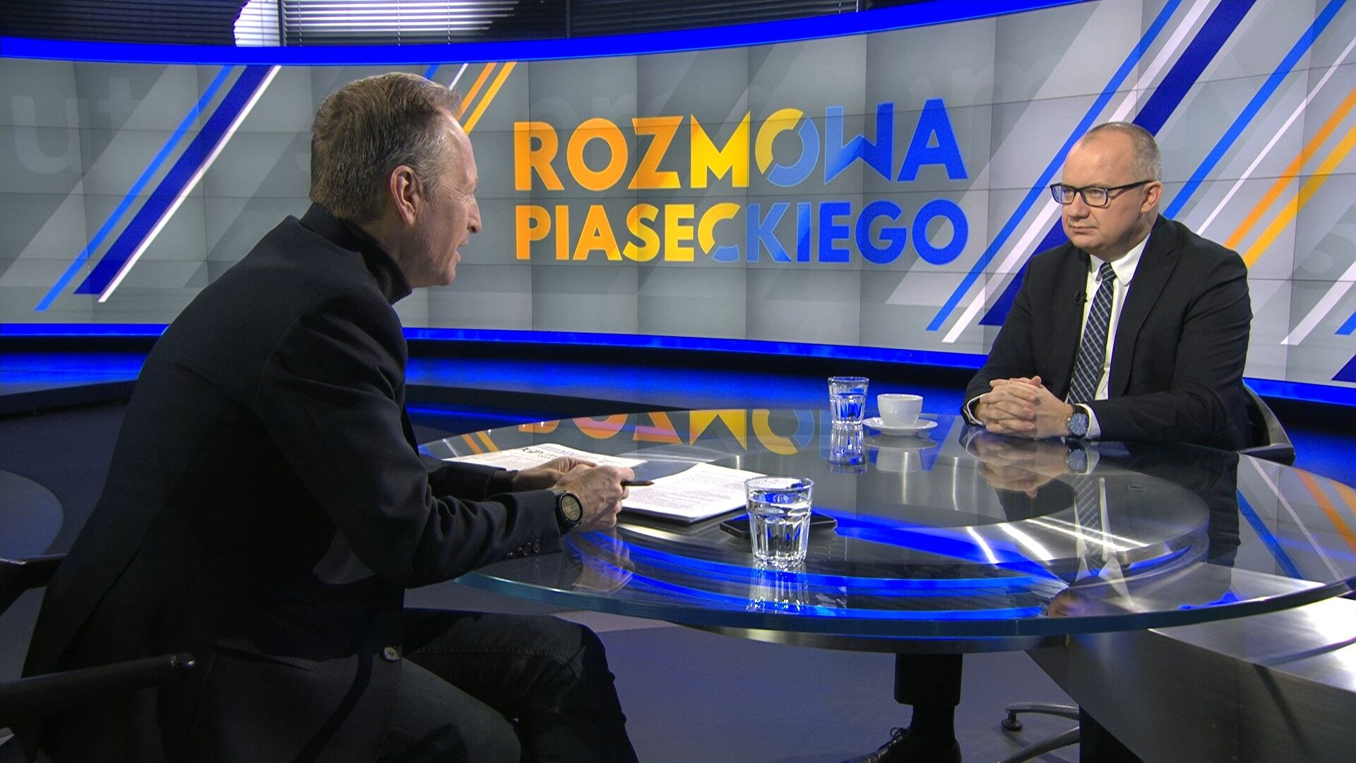 Zdjęcie przedstawiające kadr z programu - Adama Bodnara siedzącego w studiu TVN24 na przeciwko Konrada Piaseckiego